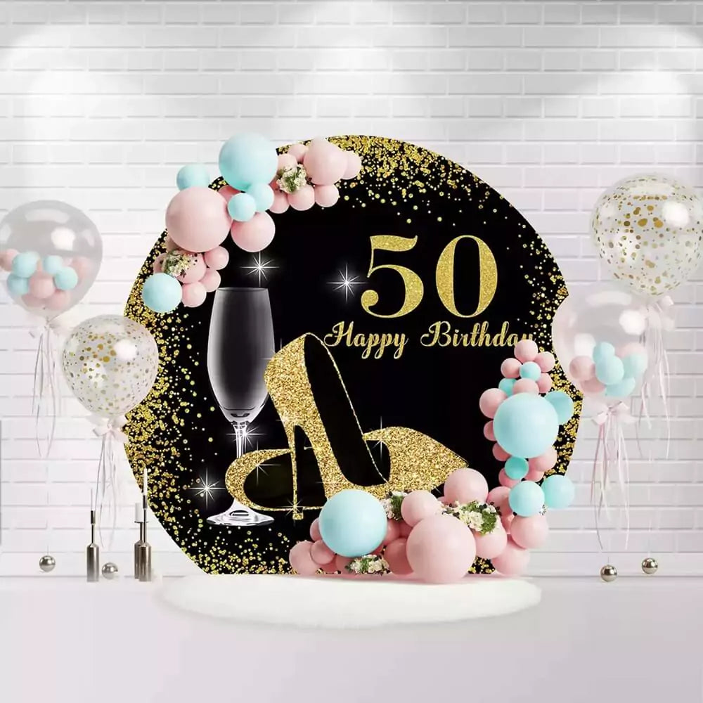Round black and gold 50th birthday backdrop with glitter high heels and champagne glass