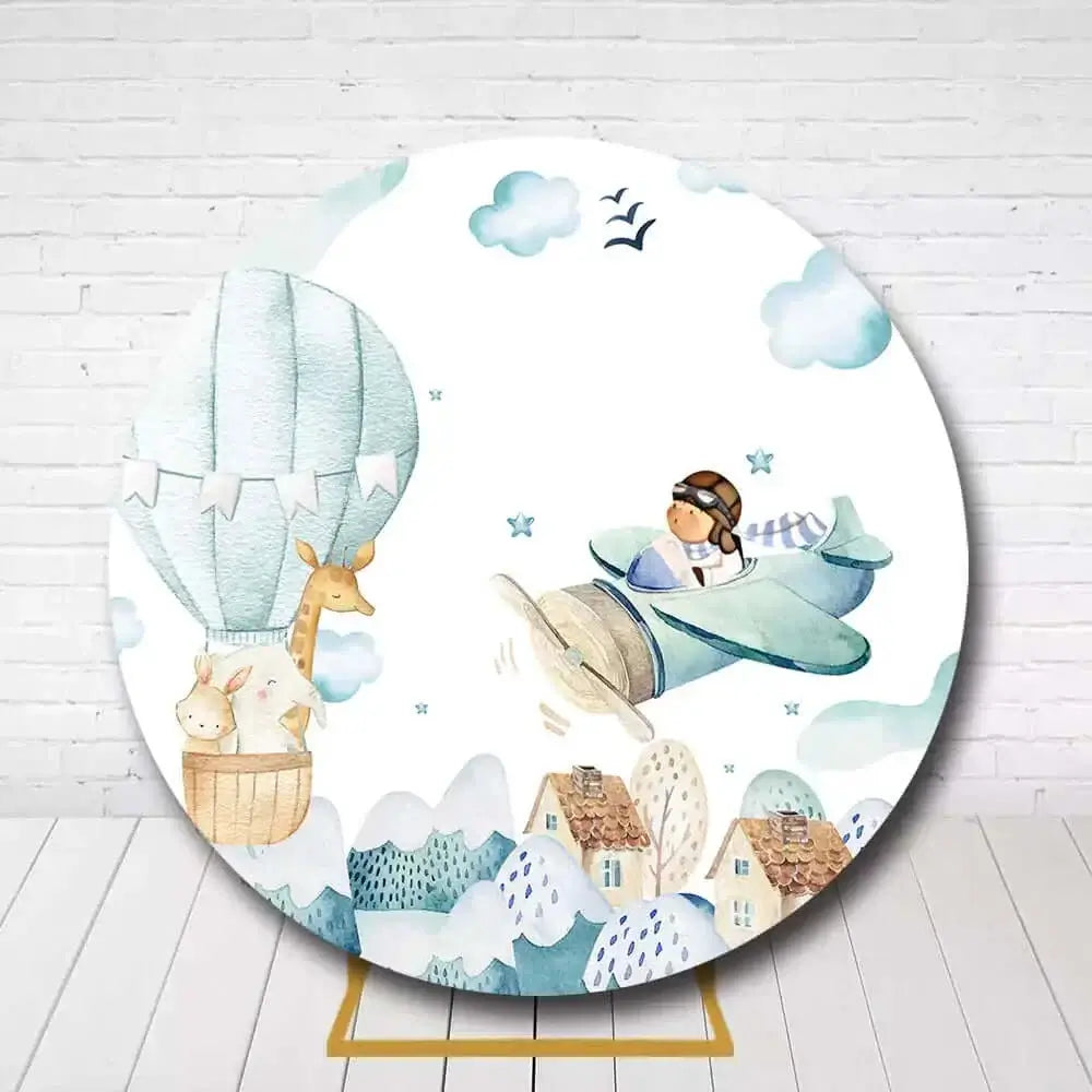 Travel theme round backdrop with airplane, balloon, and mountain design for children’s party