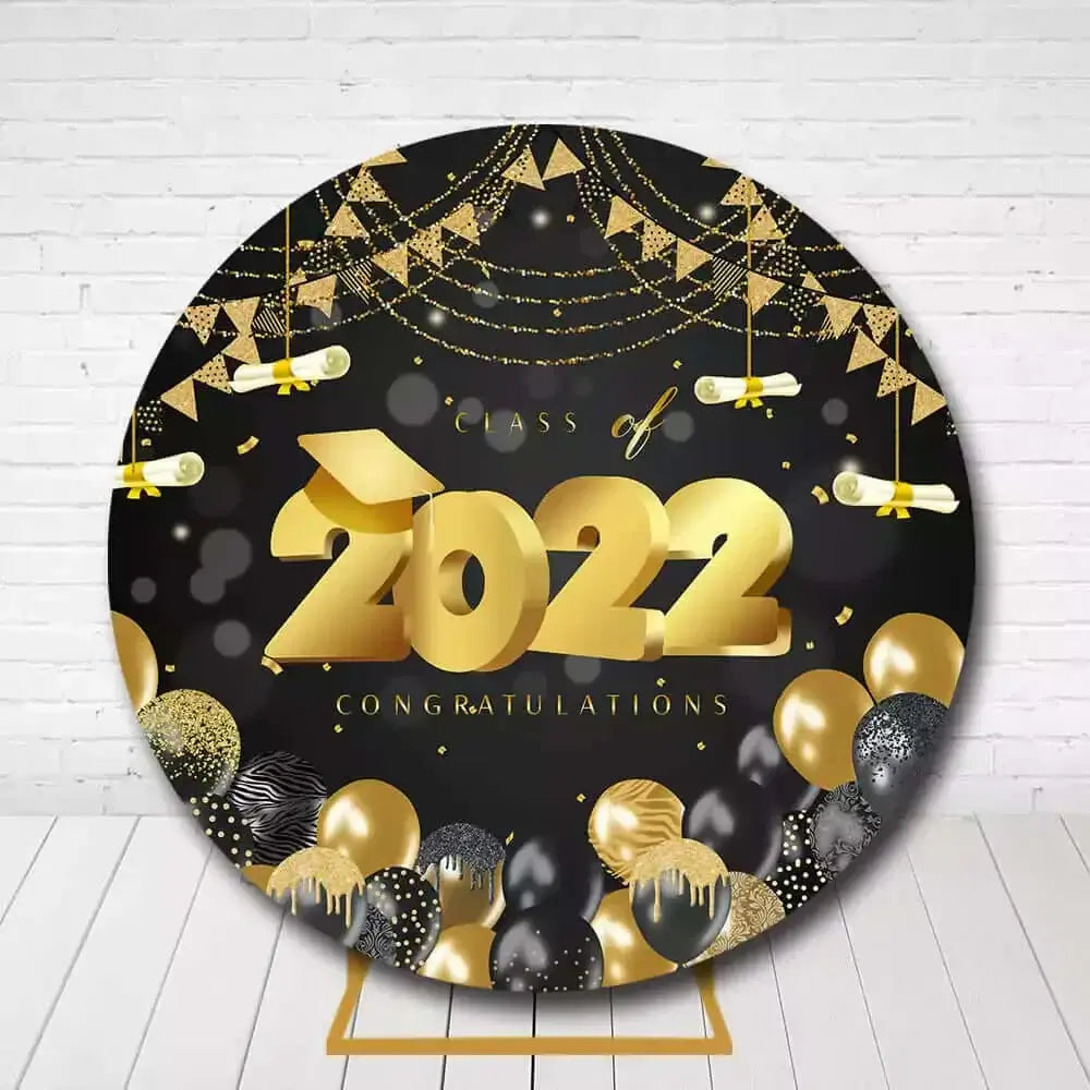 Black and gold circle backdrop featuring graduation scrolls, balloons, and decorations