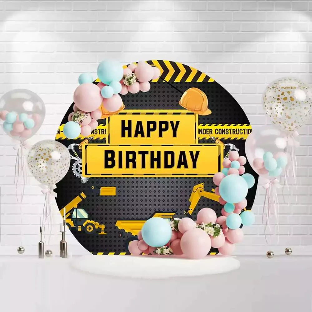 Round construction birthday backdrop with hard hats, trucks, and yellow caution tape