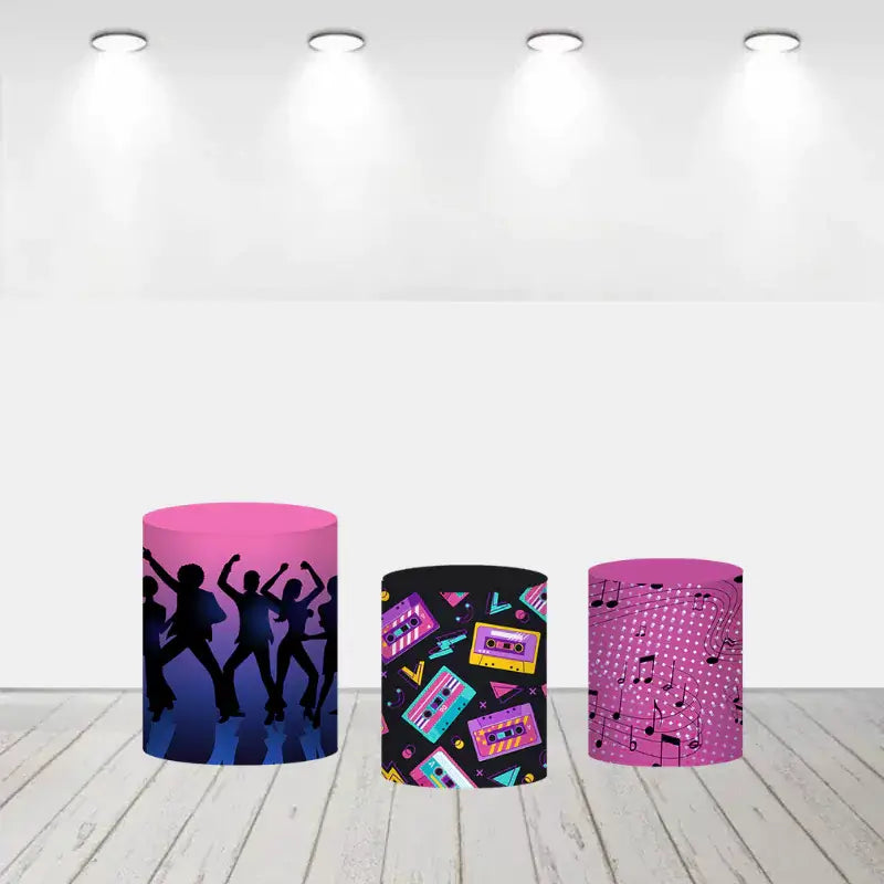Three disco-themed cylinder covers: one with silhouettes of dancing people, another with colorful cassette tapes on black, and the third featuring pink musical notes on a dotted background.