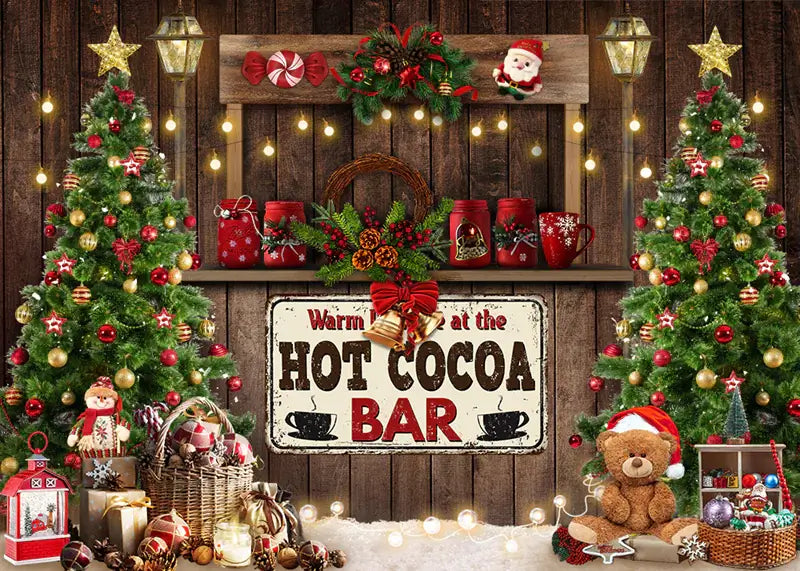 Holiday photo backdrop with a "Hot Cocoa Bar" sign, Christmas trees, and festive decor