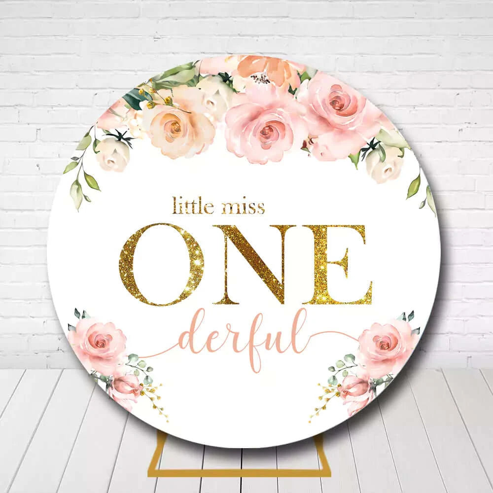 Girls first birthday circle backdrop decorated with flowers and gold glitter design