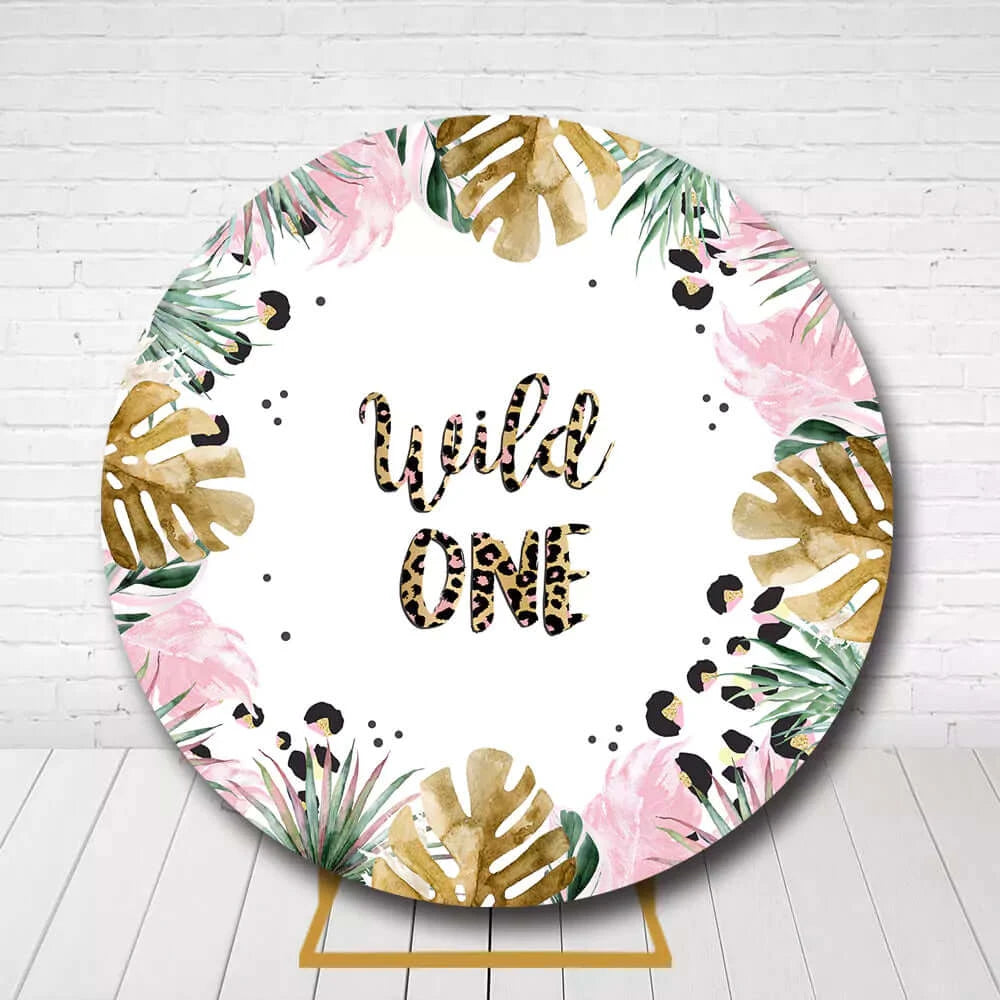Tropical jungle circle backdrop with gold monstera leaves and Wild One lettering for first birthday