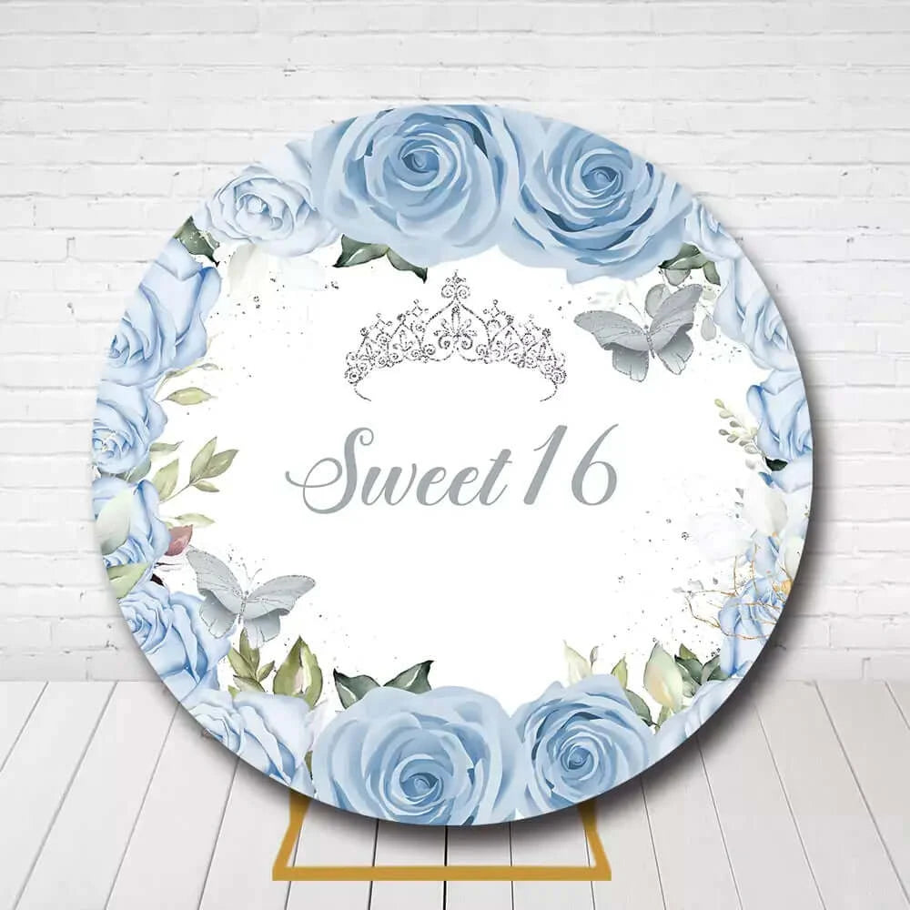 Sweet 16 round backdrop with blue roses, crown, and butterflies for birthday party