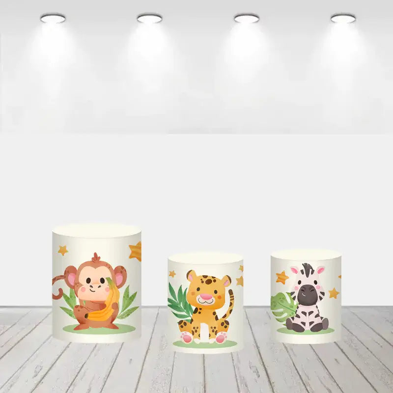 Cylinder covers decorated with adorable safari animals such as a monkey, leopard, and zebra, complementing the round backdrop.