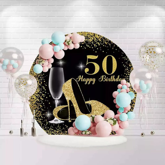 Round black and gold 50th birthday backdrop with glitter high heels and champagne glass