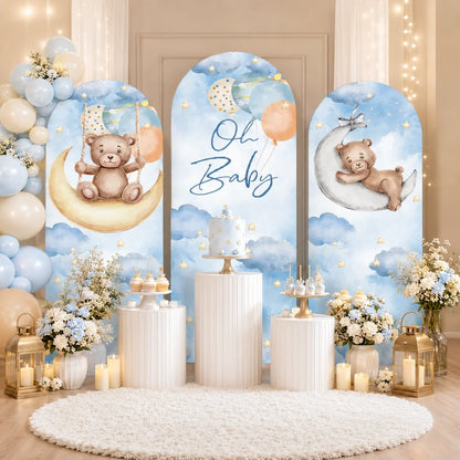 Blue teddy bear baby shower set with three arch backdrop covers featuring Oh Baby lettering, watercolor clouds, stars, balloons and bears on crescent moons.