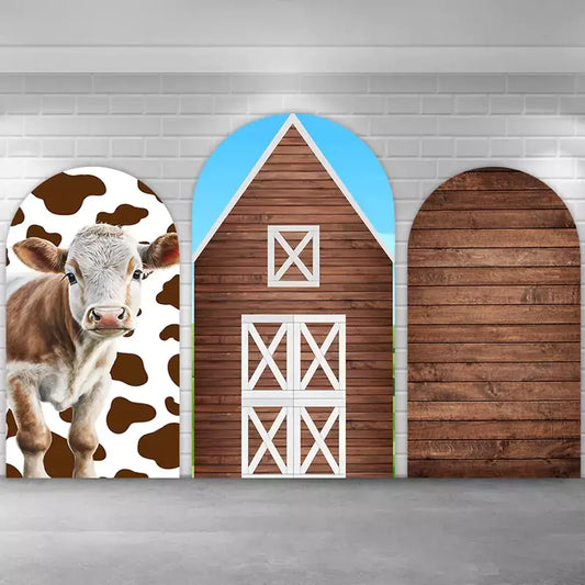 Three-piece farm-themed backdrop set featuring a cute brown-and-white cow, a rustic brown barn with white doors, and a wooden plank texture arch—ideal for barnyard birthdays, farm parties, or western-themed photo booths.