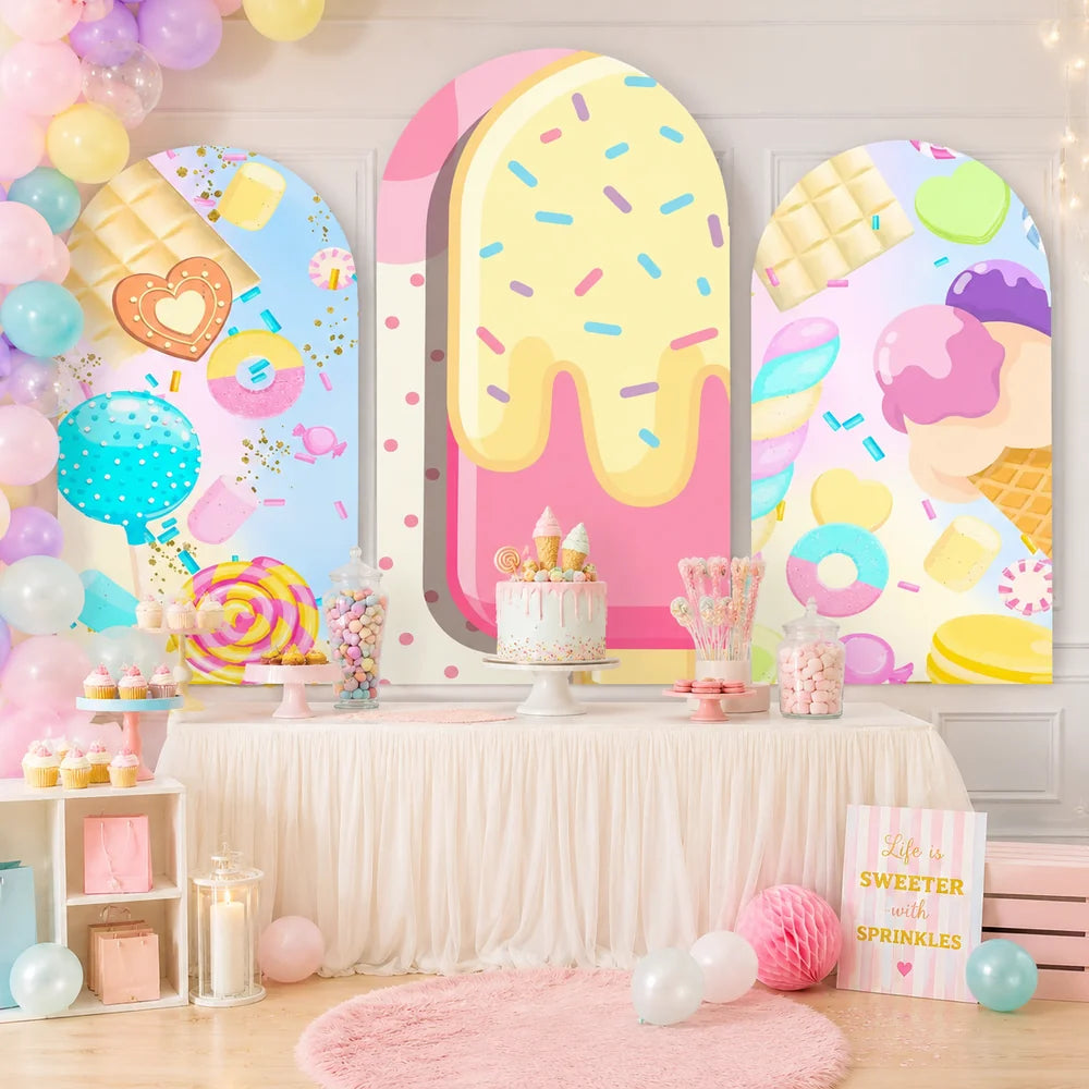Pastel candy and ice cream party set with three arch backdrop covers featuring a giant sprinkled popsicle, lollipops, macarons, ice cream cones and colorful sweets.