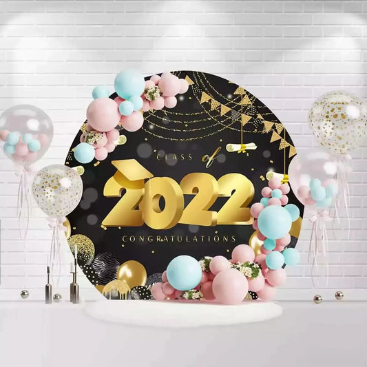 Round graduation backdrop with gold Class of 2022 text, balloons, and streamers