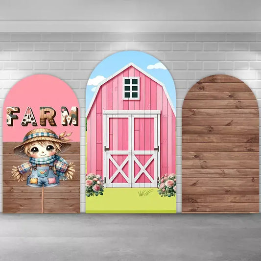 Three-piece farm party backdrop set with center pink barn and flowers, left scarecrow with ‘FARM’ cow-print letters, and right rustic wood arch—perfect for barnyard birthday or baby shower photo booth.