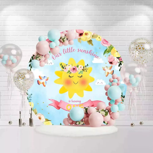 Happy birthday backdrop for one-year-old with cute smiling sun, flowers, and clouds with "Our Little Sunshine is Turning One" text