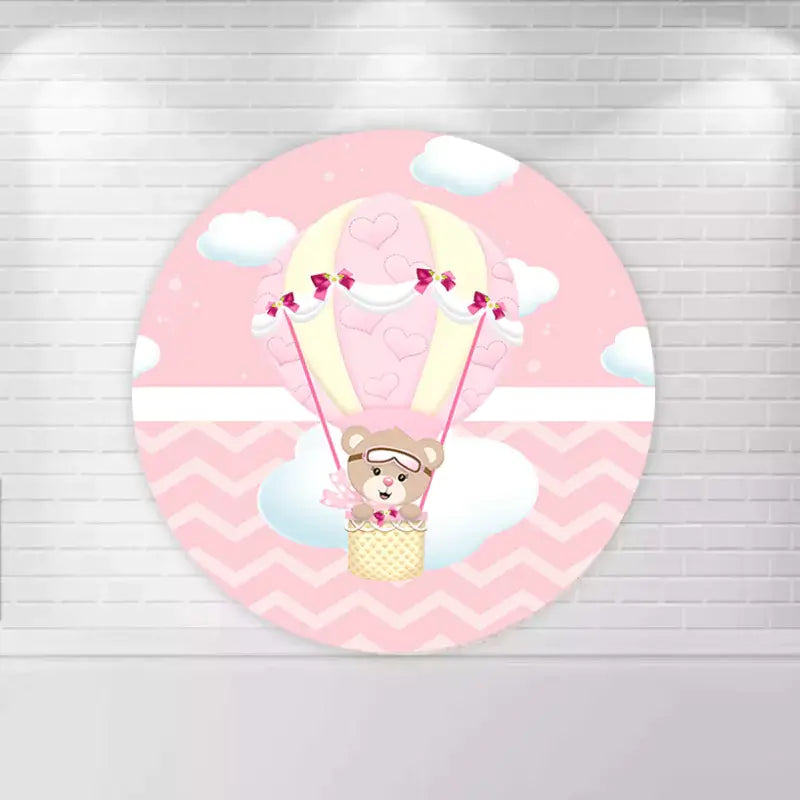 Round backdrop with a pink and yellow hot air balloon carrying a teddy bear, set against a chevron background with clouds.