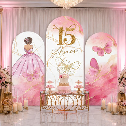Pink quinceañera party set with three arch backdrop covers featuring a girl in a pink ball gown, gold 15 Años lettering, butterflies and pink marble accents.