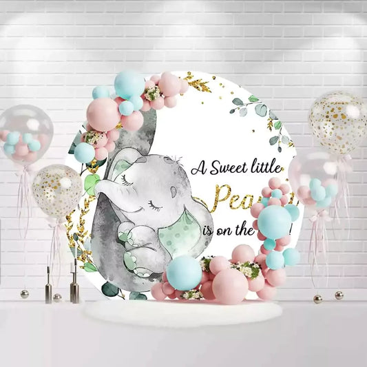 Round baby shower backdrop with cute elephant, greenery, gold accents, and Sweet Little Peanut text