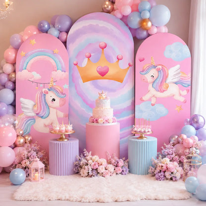 Pastel unicorn princess party set with three arch backdrop covers featuring winged unicorns, rainbow clouds, stars and a golden crown on a pink and lavender background.